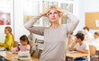 © JackF - Portrait of frustrated tired teacher against the background of a school class
