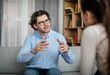 © Prostock-studio - Emotional young european guy doctor speaks and gesticulates with woman patient in office clinic interior