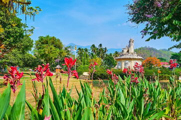 Sticker - The blooming flowers in park in front of Singha lion statue, Mae Hong Son, Thailand