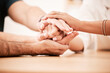 © M Einero/peopleimages.com - Support, care and family holding hands together at table to show empathy, love and hope. Closeup of connection, trust and friendship in community rehab group showing compassion and gratitude.