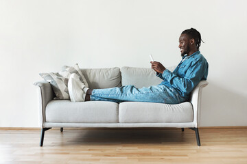 Aufkleber - Cheerful Black Man Using Mobile Phone Texting Sitting At Home