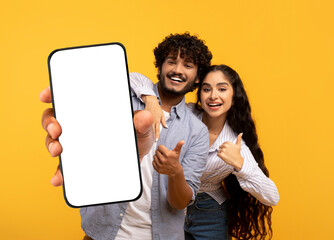 Poster - Cheerful Indian Couple Demonstrating Big Blank Smartphone And Showing Thumbs Up