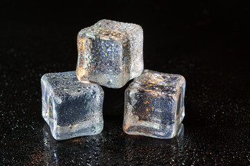 Wall Mural - ice cubes on black table background.