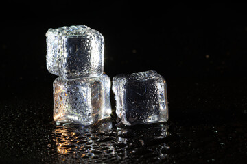 Wall Mural - ice cubes on black table background.