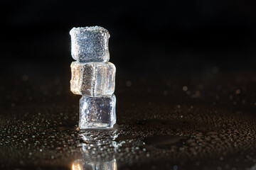 Wall Mural - ice cubes on black table background.