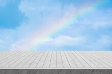 White Wooden Table With Sky And Rainbow Background.