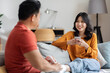 Loving asian husband massaging his smiling wife feet