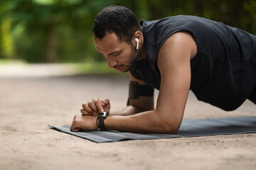 Wall Mural - Handsome young sporty black man set his fitness tracker