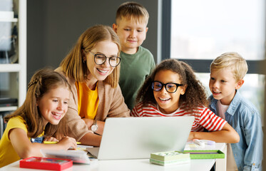 Wall Mural - Teacher and pupils using laptop