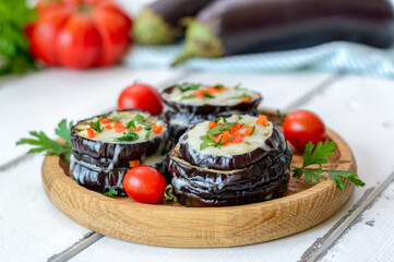 Wall Mural - Eggplant baked with mozzarella cheese, tomatoes on a wooden plate.  Vegetarian food recipe.