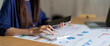 © Natee Meepian - Close up of businesswoman Accounting using calculating income-expenditure and analyzing real estate investment data report Financial and tax systems concept.