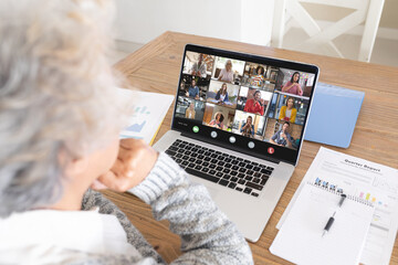 Canvas Print - Composition of senior caucasian businesswoman having video call with colleagues