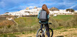 woman on bike looking at panoramic view of spanish city landscape- white house village typical (Olvera)