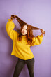 angry redhead woman tearing her hair, copyspace with purple background