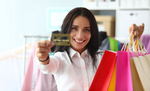 Portrait Of Woman Holding Shopping Bags In Store With Bank Credit Card