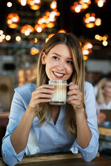 Wall Mural - Portrait of happy young business woman drinking coffee in a break.