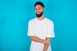 © Jihan - bearded caucasian man wearing white T-shirt over blue background laughing.