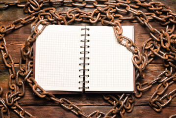 Wall Mural - open blank page notebook with copy space and old rusty iron chain on the wooden table background. to