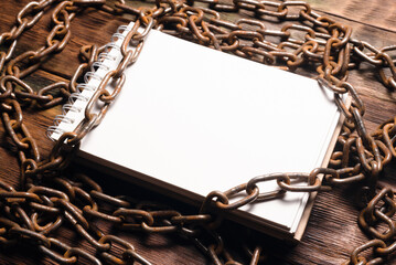 Wall Mural - open blank page notebook with copy space and old rusty iron chain on the wooden table background. to