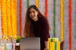© IndiaPix - Young woman laughing while working in office during Diwali celebration