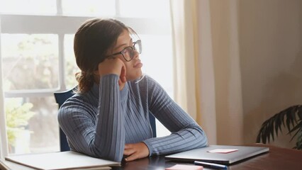 Wall Mural - One beautiful female teenager sleeping and resting on the table while studying or working at home. Millennial taking a break after doing homework using laptop.
