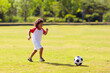 © famveldman - Cute curly little boy playing football. Kids play.