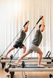 Sportsmen exercising on pilates reformer beds