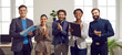 © Studio Romantic - Happy business team applauding after successful group meeting in office of modern business center. Smiling multiracial male and female colleagues stand in row and clap their hands. Panoramic banner.