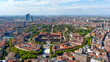 Aerial view of The Castello Sforzesco medieval fortification located in Milan, northern Italy. Flying around Sforzesco Castle citadel in Sempione Park ft. Milano urban skyline in Europe in 6K