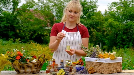 Wall Mural - Woman makes tincture with medicinal herbs. Selective focus.