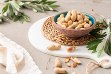 Peanuts With Shell, Dry Roasted And Unshelled Peanuts As Healthy Snack In Ceramic Bowl In Kitchen Countertop. For Healthy Food And Diet Concepts.