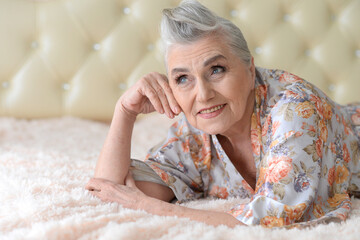 Poster - Thoughtful nice senior woman lying on bed