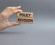 Policy revision symbol. Concept word Policy revision on wooden blocks. Beautiful grey background. Businessman hand. Business and Policy revision concept. Copy space