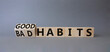 © Natallia - Good and bad Habits symbol. Turned wooden cubes with words Bad Habits and Good Habits. Beautiful grey background. Medicine concept. Copy space