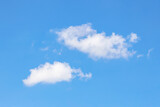 Fototapeta Niebo - White clouds against a clear blue sky, warm summer day