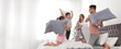 © New Africa - Happy family having pillow fight in bedroom, space for text. Banner design