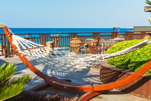 Wicker Hammock Overlooking The Sea In Cyprus. Wicker Sunbed In The Tourist Area Next To The Pool. Special Areas For Guests To Relax In The Cafe
