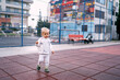 © Oleksandra - Little girl with a ponytail walks in the playground near an apartment building. High quality photo