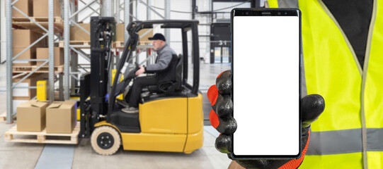 Poster - Warehouse apps. Mobile phone template. Phone in hand warehouse worker. Smartphone with white screen. Concept apps for tracking goods in stock. Place for website in phone screen. Forklift blurred