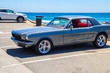 A Gray And Red Ford Mustang Parked At The Beach Surrounded By Vast Blue Ocean Water At Royal Beach Park On White Point Beach In San Pedro California USA