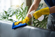 © crizzystudio - Close-up: Hands of a restaurant worker cleaning the surface of a sofa and spraying disinfectant during the coronavirus outbreak. Use a cleaner or use alcohol to disinfect the restaurant.