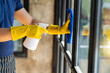 Close-up of a restaurant worker's hand cleaning a window glass and spraying disinfectants during the outbreak of the virus Use a cleaner or use alcohol to disinfect the restaurant.