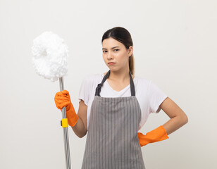 Young woman with apron and rubber glove tired of cleaning the house on isolated white background. Housekeeping housework or maid worker holding mop