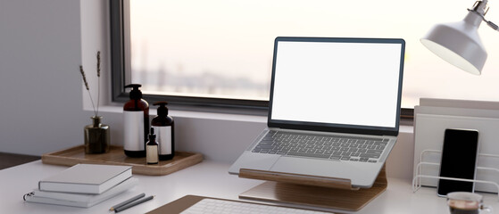 Canvas Print - modern urban home office workspace by the window with notebook laptop mockup on a laptop stand
