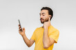 © juanpablo - young latin queer man connecting wireless touch ear buds to his cell phone. white background