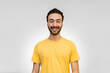 © juanpablo - young latin man with braces smiling looking at camera, white background with yellow shirt