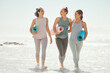 © David Lahoud/peopleimages.com - Beach yoga, fitness women and happy friends excited, smile and laughing for exercise, fresh workout and body wellness at sea. Healthy people walking, summer ocean pilates training and sunshine energy