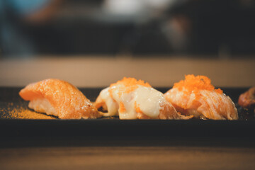 Wall Mural - Fresh Japanese sushi salmon in Japanese restaurant. Eating Japanese food such as salmon sushi and sashimi is healthy and tasty. Salmon sushi and Japanese food concept.