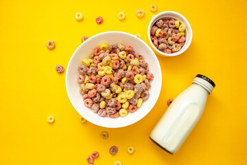 Wall Mural - Healthy breakfast concept, Colorful ring cereals in large bowl and mini bowl with milk in bottle