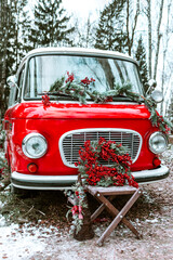 red bus decorated with Christmas wreath, blankets, pillows and gift boxes with presents is standing in forest, Santa Claus's magic transport, New Year and Christmas banner background